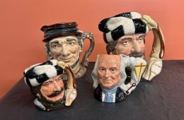 128. Four (4) Royal Doulton Jugs - (2) Trapper - (1) Johnny Appleseed - (1) Ben Franklin